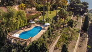 An aerial view of a resort with a swimming pool, lounge chairs, and a view of the sea. - Awesome home in Almuñecar (Almuñecar)