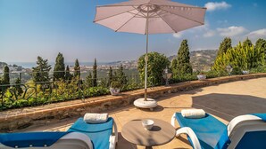 A terrace with two sun loungers, a table, and an umbrella. - Awesome home in Almuñecar (Almuñecar)