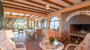 A spacious patio area with a brick fireplace, wicker furniture, and a view of the outdoors. - Awesome home in Almuñecar (Almuñecar)