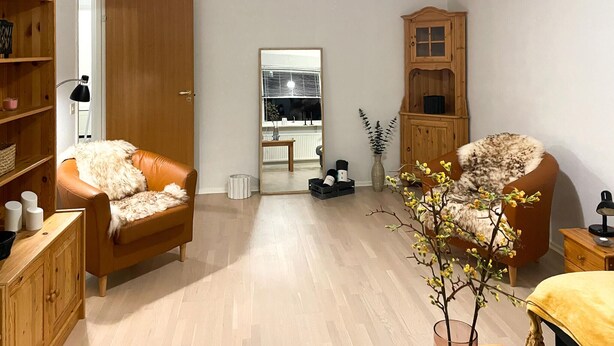 A cozy living room with two leather armchairs, a wooden cabinet, and a small table. - Nice apartment in Hyltebruk with WiFi (Hyltebruk)