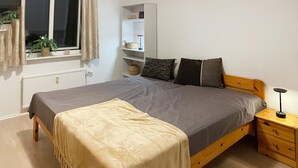 A neatly arranged bedroom with a bed, bedside tables, a shelf unit, and a window with curtains. - Nice apartment in Hyltebruk with WiFi (Hyltebruk)