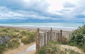 A beach view with a wooden fence and grassy dunes. - Beautiful home in Courtils with WiFi (Courtils)