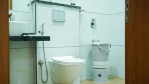 Een badkamer met toilet, wastafel en douche.