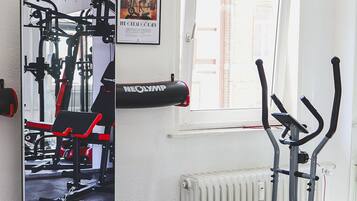 A gym with exercise equipment, a window, and a radiator.