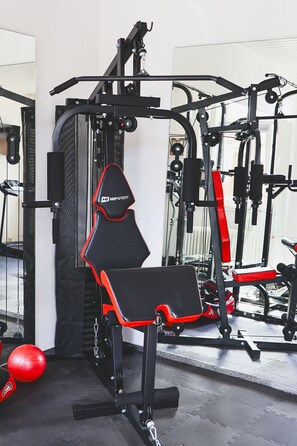 Una palestra con attrezzature per esercizi, tra cui una panca e macchinari per il sollevamento pesi.