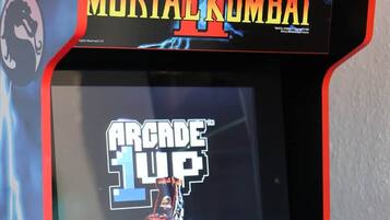 A Midway arcade machine with Mortal Kombat II and Arcade 1UP titles.