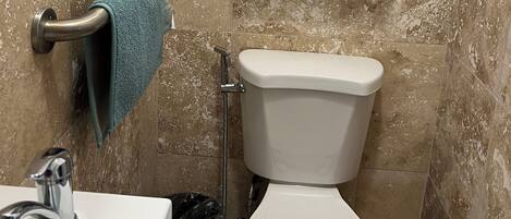 Ein Badezimmer mit Toilette, Waschbecken und Handtuchhalter.