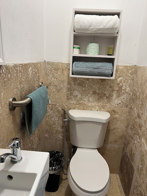 A bathroom with a toilet, sink, and towel rack.