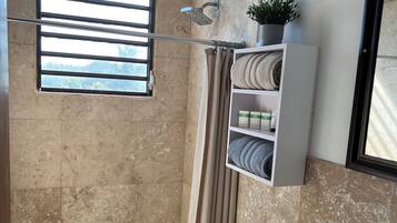 Une salle de bain avec douche, toilettes et lavabo.