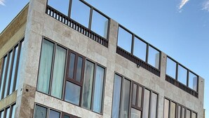 Un edificio de varios pisos con ventanas grandes y techo plano.