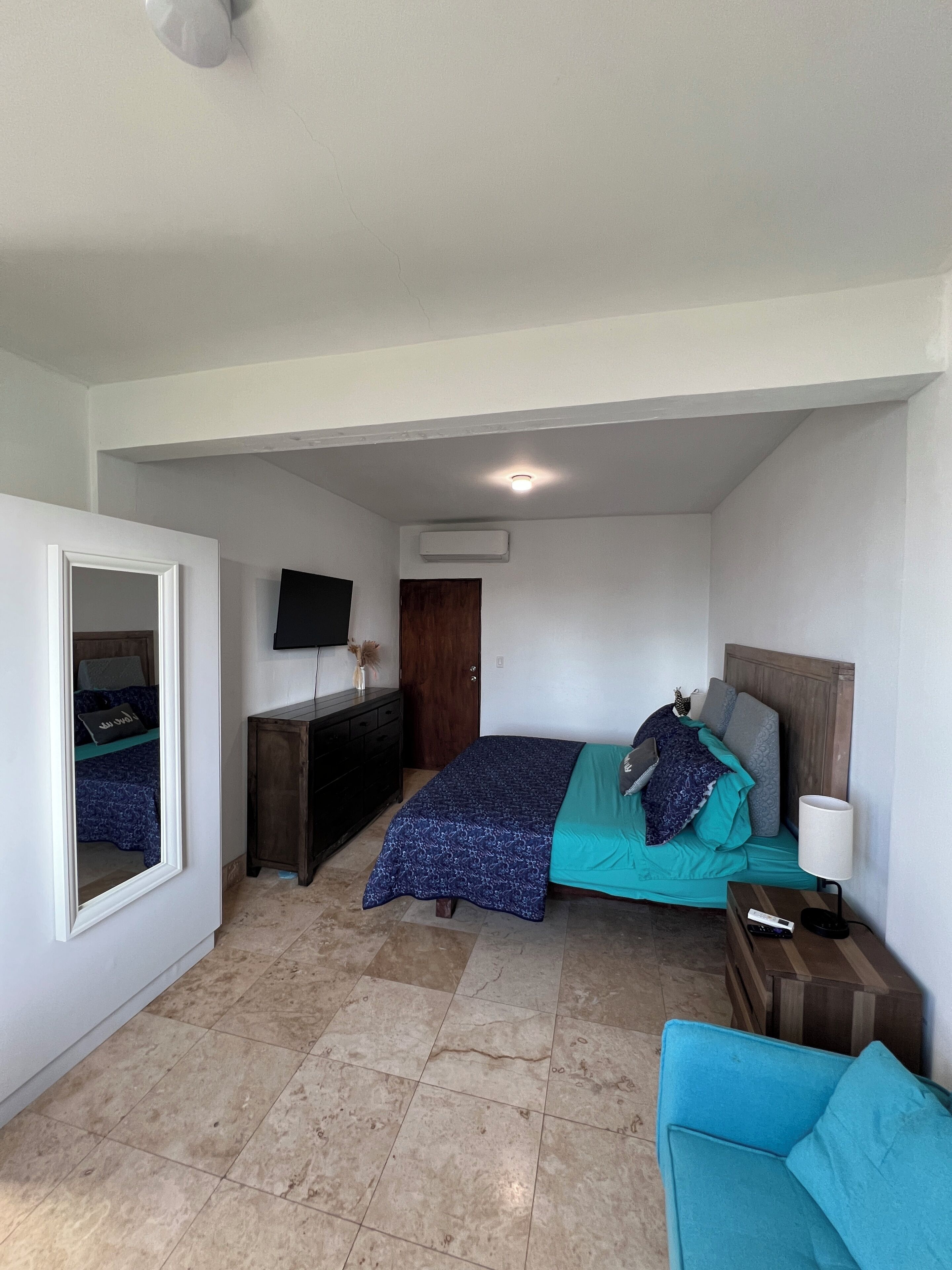 Una camera da letto con un letto, una televisione, una scrivania e una sedia.
