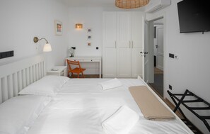 Relax in a spacious room with a large bed, desk, and wardrobe, perfect for a comfortable stay.