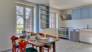 A kitchen with a dining table, chairs, and modern appliances.