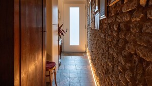 A narrow hallway with stone walls, wooden beams, and a tiled floor. - Historic housing in pedestrian square - Borgo Portello (Padova)