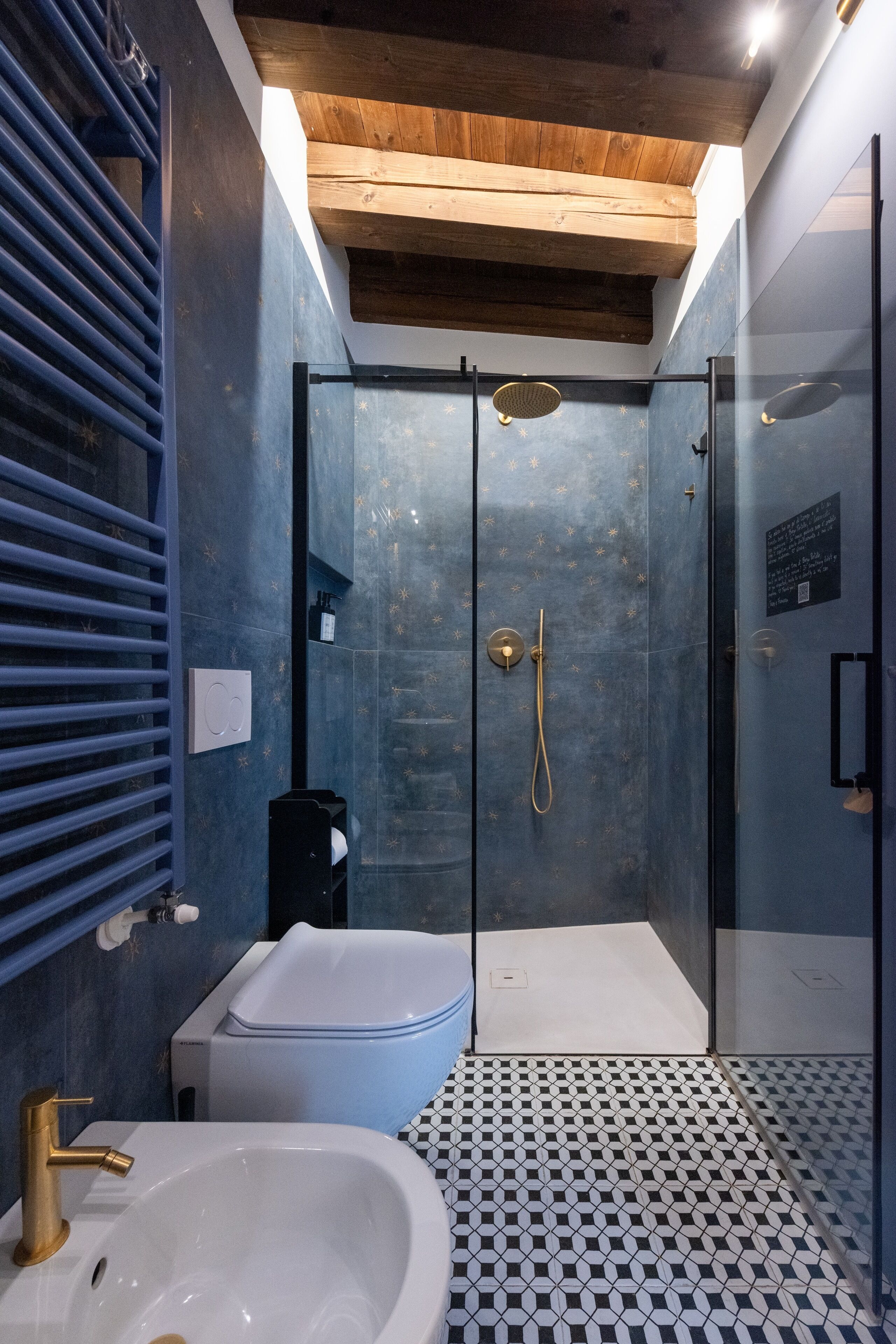 A modern bathroom with a glass-enclosed shower, a white bathtub, and a black and white checkered floor.