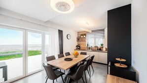 A modern kitchen with a wooden countertop, a coffee machine, and a window with blinds.