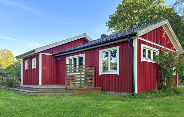 A red wooden house with a small porch and a window. - Cozy home in Lidhult with house a panoramic view (Lidhult)