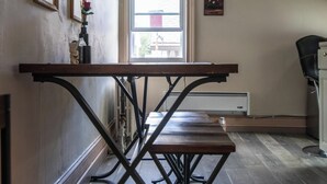 Una habitación con una mesa de madera, un radiador y una ventana.
