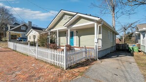 A single-story house with a front porch, a white picket fence, and a brick driveway. - Family Getaway Near Zoo & Downtown Fun! Sleeps 10 (Atlanta)