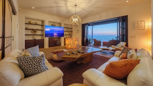 A living room with a large TV, a wooden coffee table, and comfortable seating.