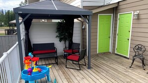 A covered patio with a play area, a bench, and a door. - Candle Lake retreat backing the 5th green of the golf course. (Candle Lake)