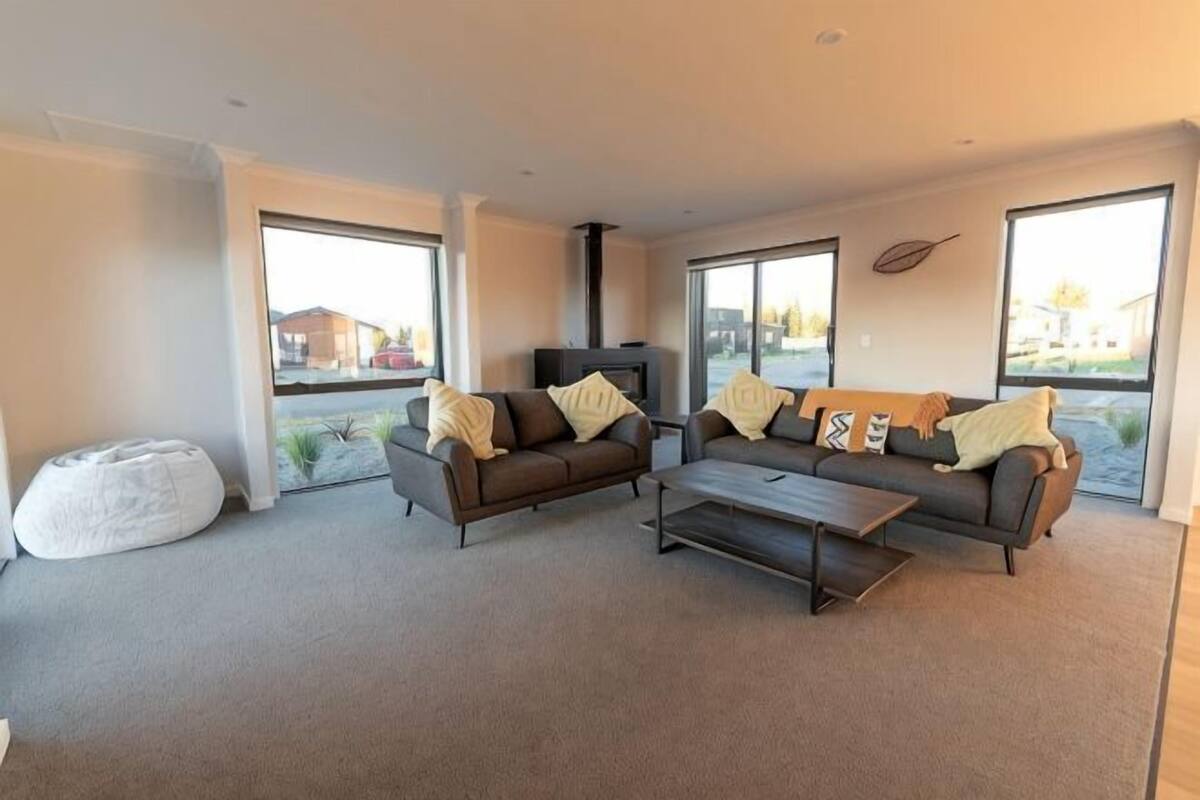 A modern living room with two sofas, a coffee table, and a large window.