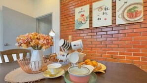 Una mesa de comedor con un florero, un cuenco, platos y una tetera.