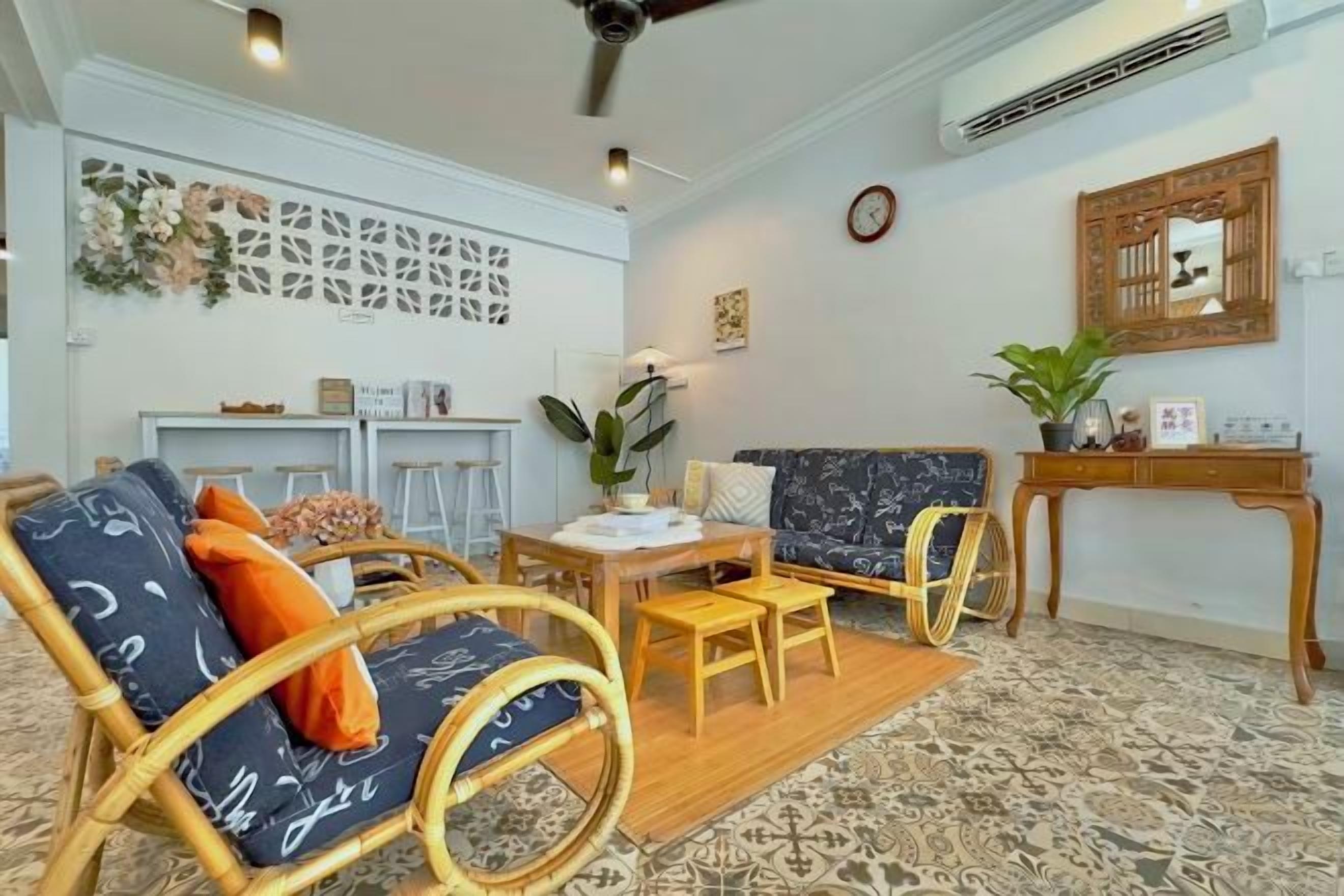 A room with a sofa, chairs, a dining table, and a small table with a plant.