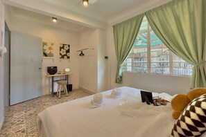 A hotel room with a bed, a desk, a chair, a TV, and a window with curtains. - NewWALAI N3 Landed house near IMAGO KK CarGarage (Kota Kinabalu)