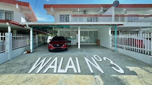 Un edificio con un coche rojo estacionado en la fachada, con la leyenda "WALAI NO 3".