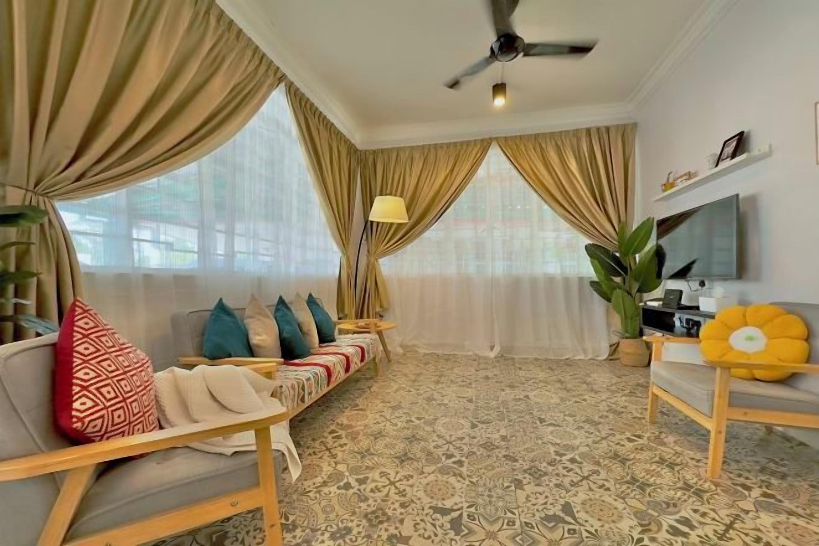 A living room with a sofa, a TV, and a patterned carpet.