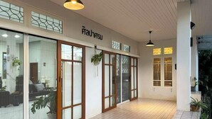 A spacious interior with sliding glass doors, wooden flooring, and hanging plants. - Silpasom ARTstay Suratthani (Phunphin)
