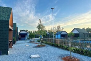 En innergård med en grusgång, ett trästaket och flera byggnader med blå tak.