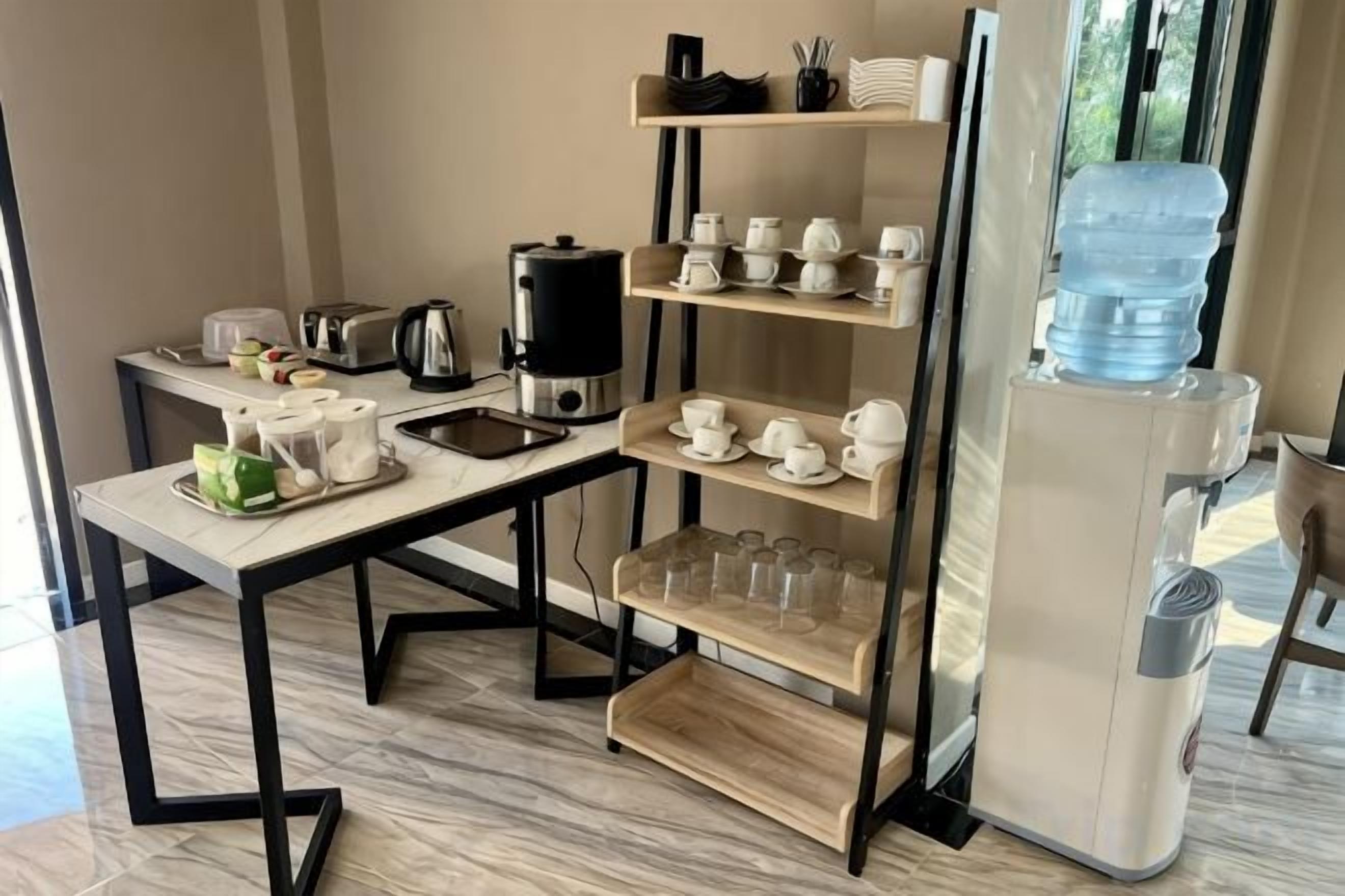 A kitchenette with a coffee maker, toaster, and water dispenser.