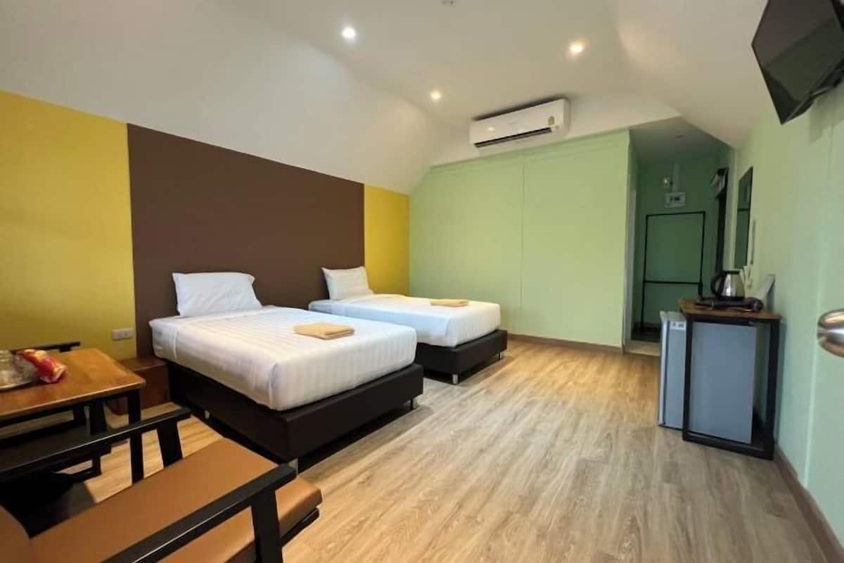 A room with two beds, a small table, and a TV.