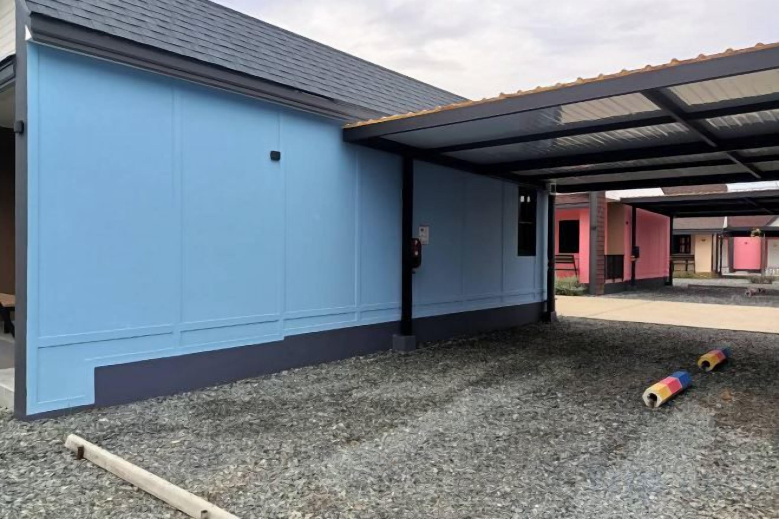 A building with a blue exterior and a covered outdoor area.