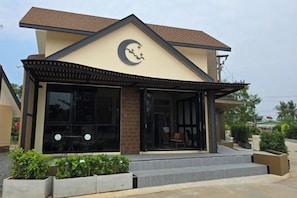 A building with a modern architectural style, featuring a prominent crescent moon symbol on the facade, large windows, and a covered entrance area.