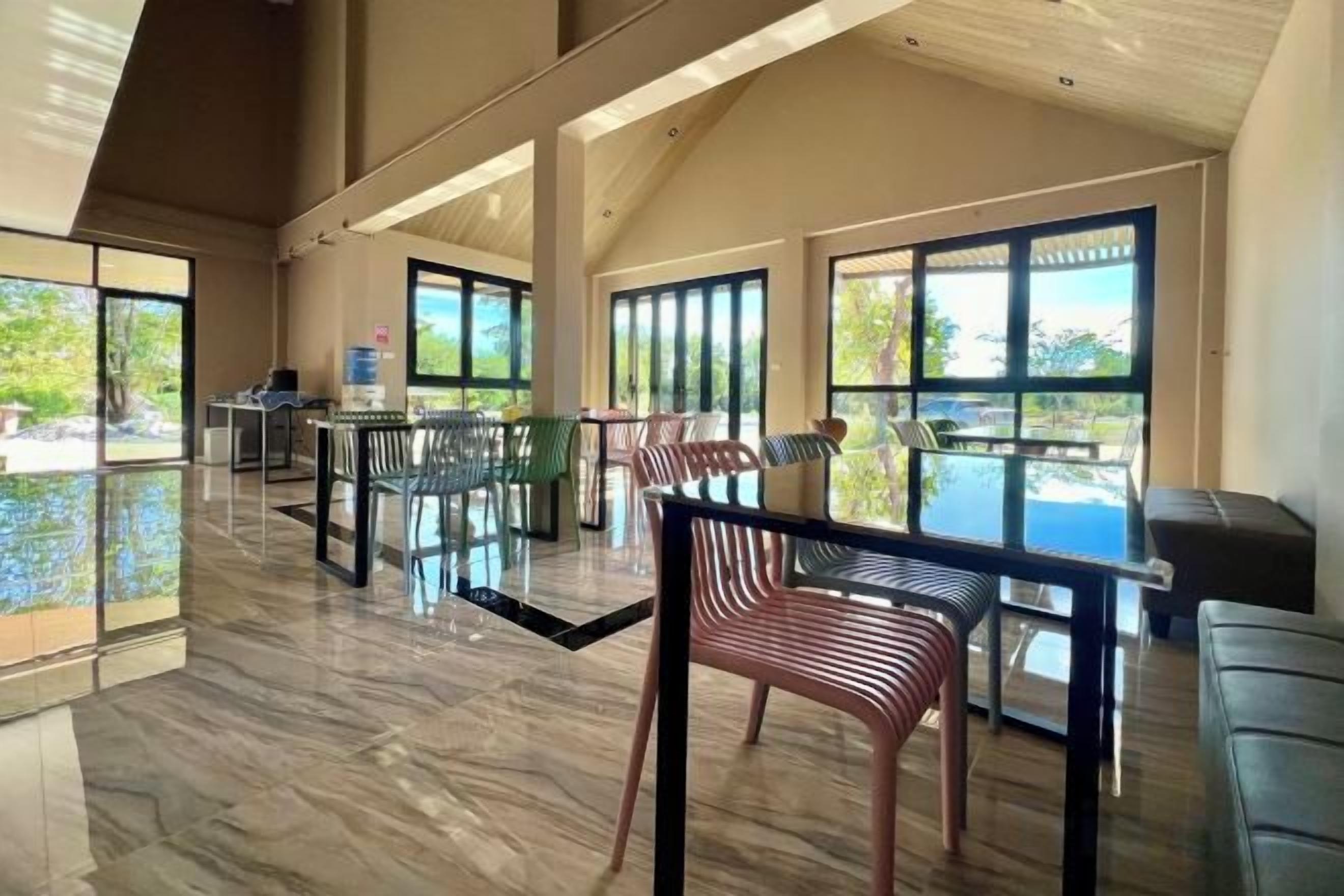 A spacious indoor area with a pool, multiple tables, and chairs arranged for dining or socializing.