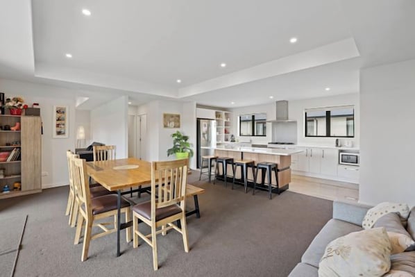 A modern interior with a dining area, kitchen, and living space. - Hunter Hunter (Lake Tekapo)