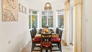 A dining area with a wooden table, chairs, and a chandelier.