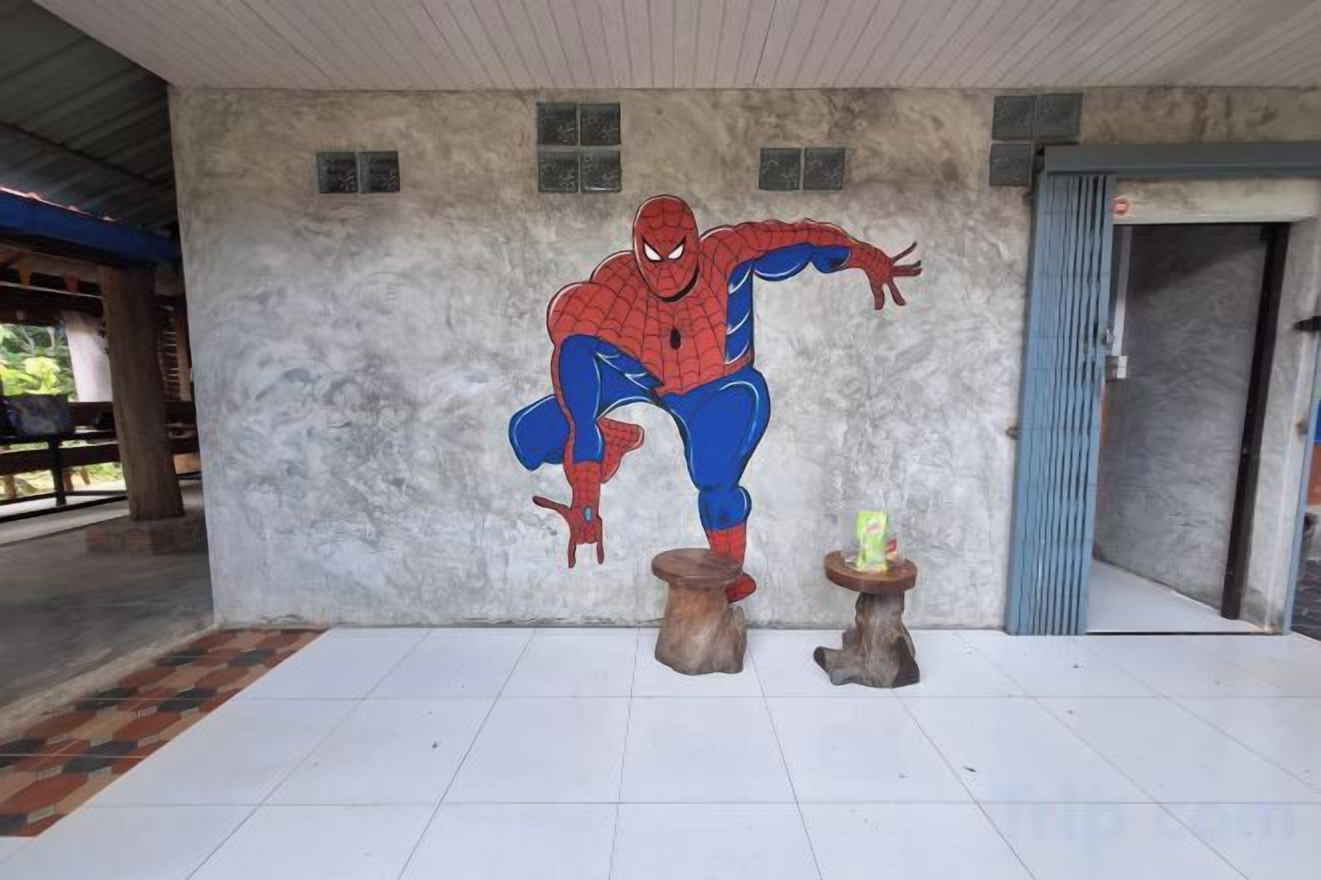 A mural of a superhero on a wall, a door, and a tiled floor.