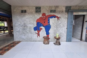 Um mural com um super-herói em uma parede, uma porta e um chão de azulejos.