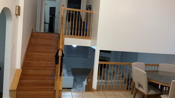 A staircase leading to a second floor with a dining area below.