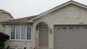 A single-story house with a garage, a front door, and a small window.