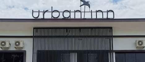 Un edificio con un letrero que dice 'urban inn' y un logo de pájaro sobre la entrada.