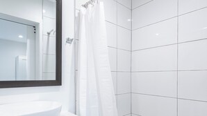 A modern bathroom with a white sink, a large mirror, and a shower area with white tiles and a hexagonal pattern on the floor. - Spacious 5-bed, 5-bath apartment in charming Los Angeles (Los Angeles)