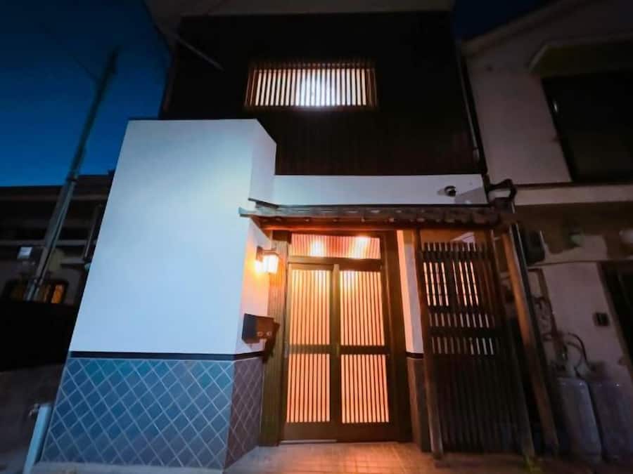 A modern building with a gated entrance, a visible staircase, and a tiled ground.