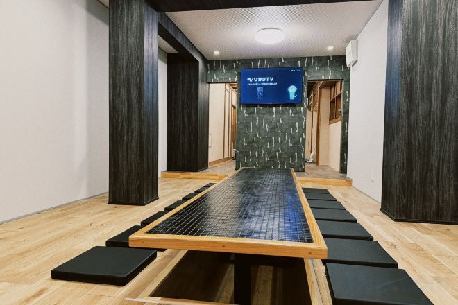 A room with a tatami mat floor, a tatami mat table, and a television screen displaying 'VAST TV'.