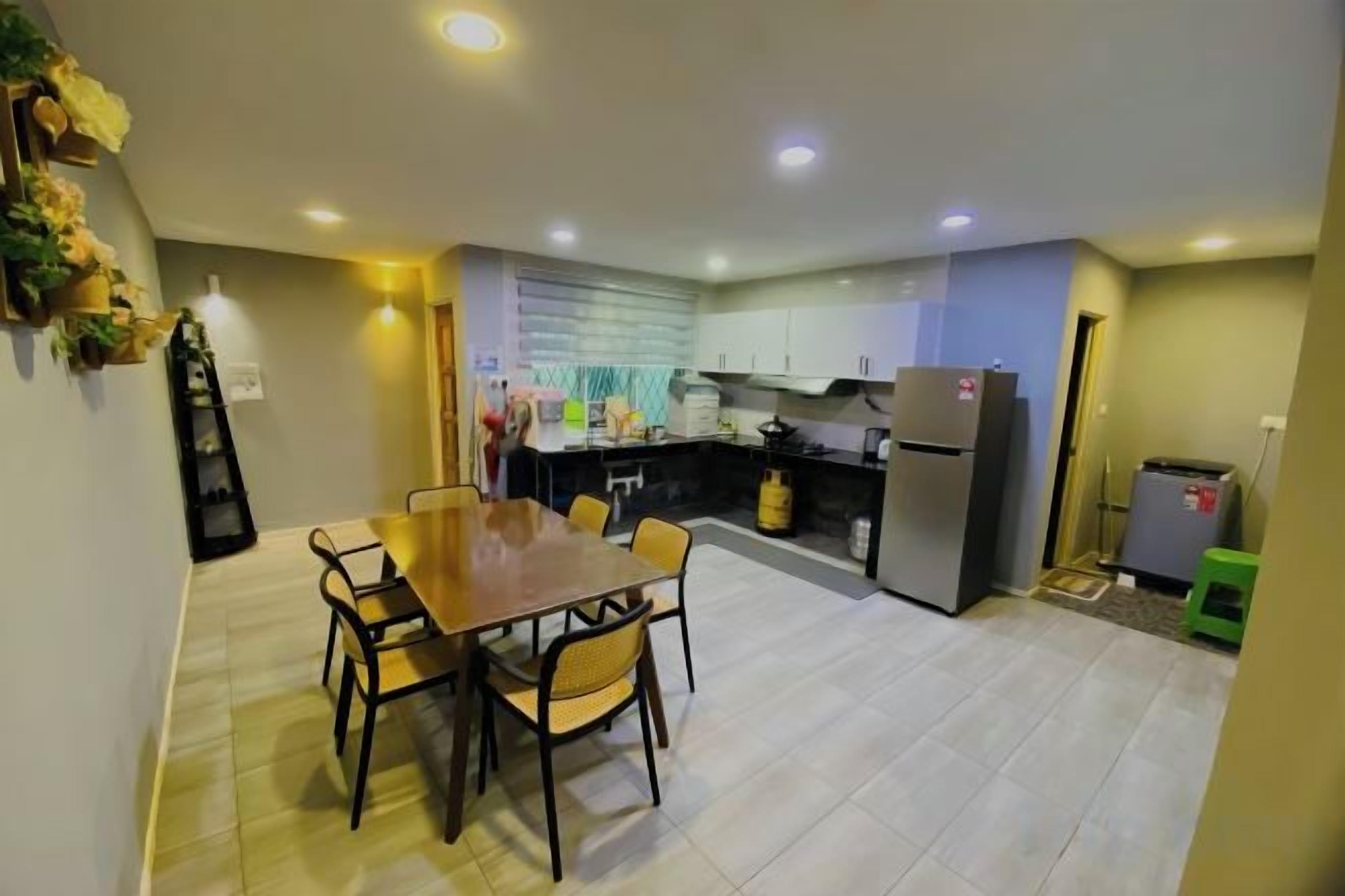 A modern kitchen with a dining table and chairs, a refrigerator, and a gas stove.