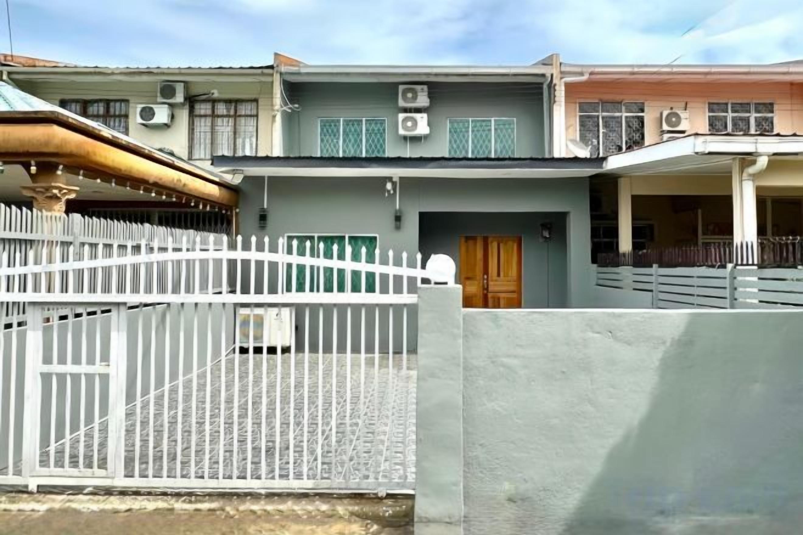 A residential building with a gated entrance, a visible door, and a balcony.